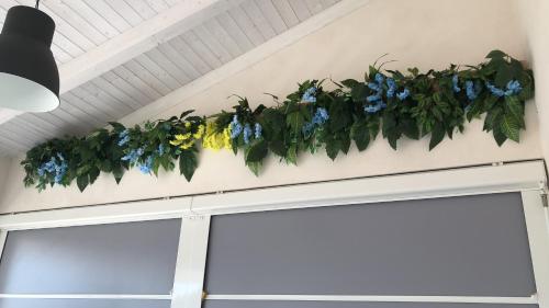 a garland of blue and yellow flowers hanging over a garage door at B&B Dionea in Santa Maria di Castellabate