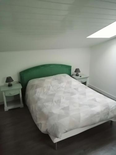 - une chambre avec un grand lit et 2 tables de chevet dans l'établissement CHEZ MARTINE Appt climatisé 1 Chambre, à Capbreton