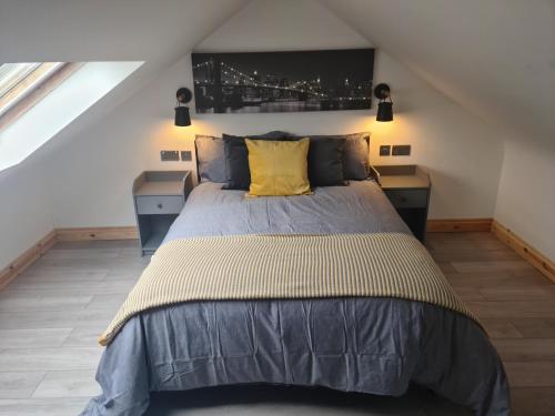 a bedroom with a large bed with a yellow pillow at The Studio in Farmborough