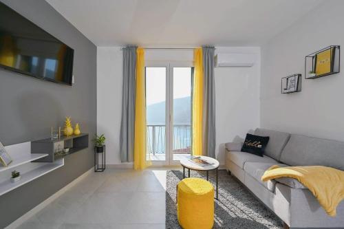 een woonkamer met een bank en een groot raam bij Apartment Noemi with a direct beach view in Rabac