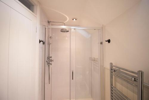 a shower with a glass door in a bathroom at The Old Cider House in Hay-on-Wye