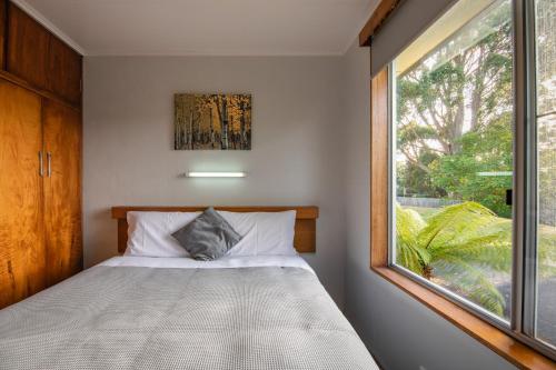 a small bedroom with a bed and a window at Marsden Court Apartments Now incorporating Marsden Court and Sharonlee Strahan Villas in Strahan