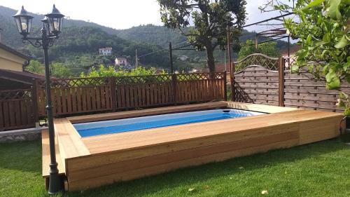 een zwembad in een tuin met een houten terras bij Agricanto in Sestri Levante