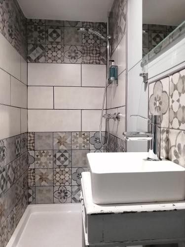 La salle de bains est pourvue d'un lavabo blanc et d'une baignoire. dans l'établissement La Vieille Gorce - Chambres d'Hôtes in the Vienne, à Asnois