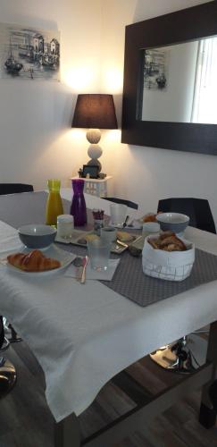 uma mesa com tigelas e pratos de comida em Belle de nuit em Le Trait dʼUnion