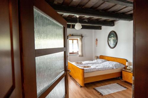 a small bedroom with a bed and a door at Ubytovanie na včelej farme in Polichno