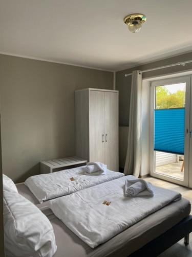 een slaapkamer met 2 bedden en een raam bij Haus Meeresgruß in Cuxhaven