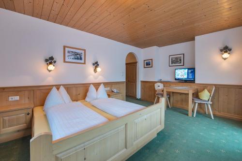a bedroom with a large bed and a television at Haus Moostal in Sankt Anton am Arlberg