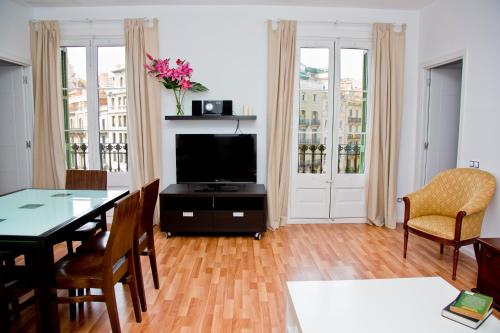 a living room with a table and a television at Claris Apartments in Barcelona
