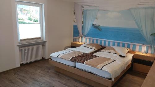a bedroom with a bed with a view of the ocean at FeWo Waldblick in Waxweiler