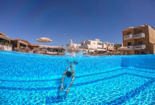 a swimming pool in a hotel with a water fountain at Giannarakis Beach in Stalos