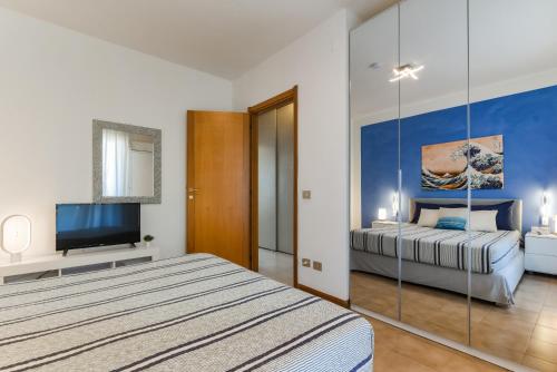 a bedroom with a bed and a flat screen tv at Dario apartment - Magnolia Holidays in Fertilia