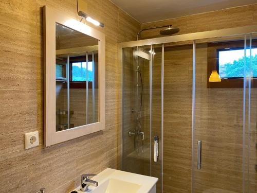 a bathroom with a shower and a sink and a mirror at Apartamentos Turísticos Casa Nieves in La Franca