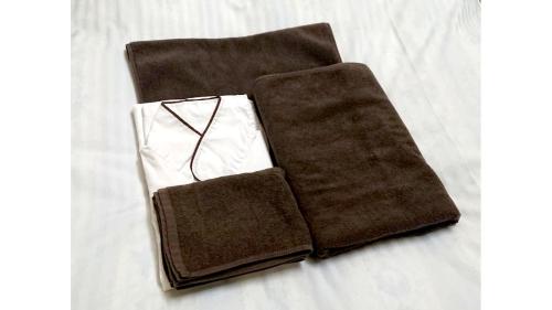 a pair of brown napkins sitting on a bed at Hotel New Century Sakaide in Sakaide