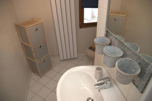une salle de bain avec un lavabo et un miroir dans l'établissement Gîte alsacien, à Eckwersheim