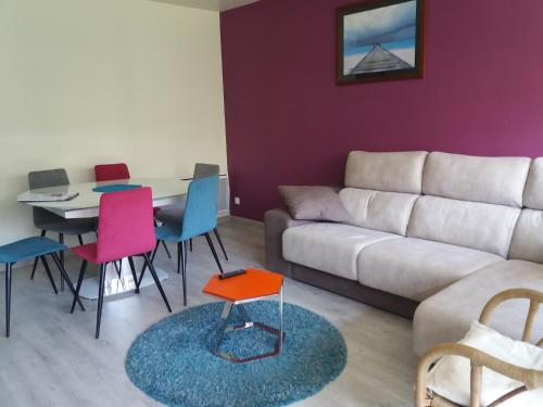 un salon avec un canapé, une table et des chaises dans l'établissement SOLEIL 4 ét, à Saint Cyprien Plage