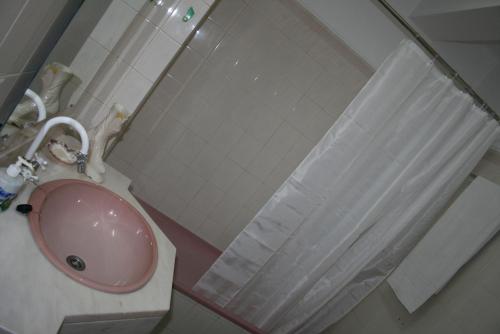 a bathroom with a pink sink and a shower curtain at Fuzeta beach holiday apartment in Fuzeta