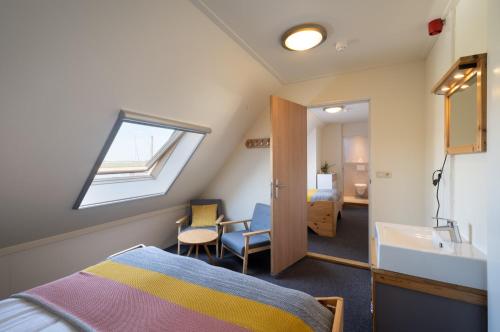 a bedroom with a bed and a sink and a window at Rufus aan het water in Broek