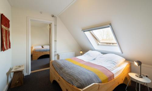a bedroom with a large bed with a window at Rufus aan het water in Broek