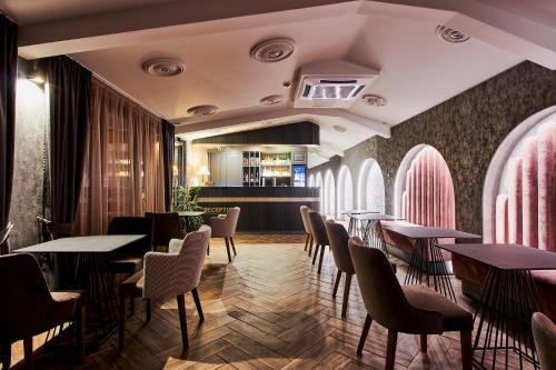 um restaurante com mesas e cadeiras e um bar em Хотел Паризи em Kazanlŭk