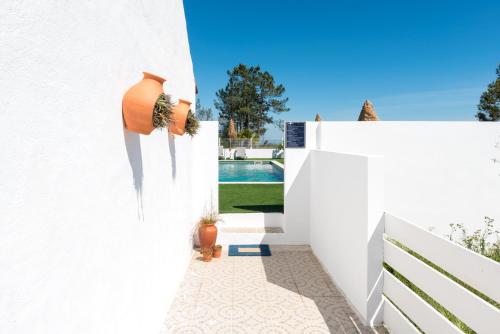 a white house with a courtyard with a pool at Quinta Bogesi in Figueira da Foz