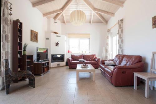 Una sala de estar con dos sofás y un televisor. en SESI VIEW, en Grammatiko