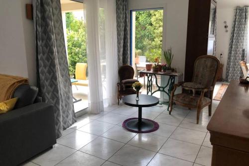 un salon avec une table et des chaises dans l'établissement Location maison 2 chambres, à Carnac