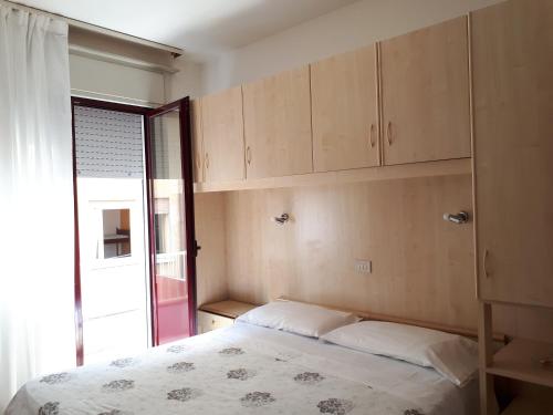 a bedroom with a bed and cabinets and a window at Hotel Villa Dina in Lido di Jesolo