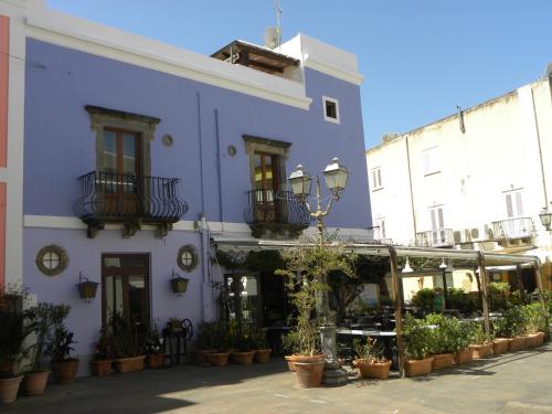 un bâtiment bleu avec des plantes en pot devant lui dans l'établissement Case Vacanze Albamarina, à Lipari