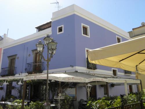 a blue building with a street light and an umbrella at Case Vacanze Albamarina in Lipari