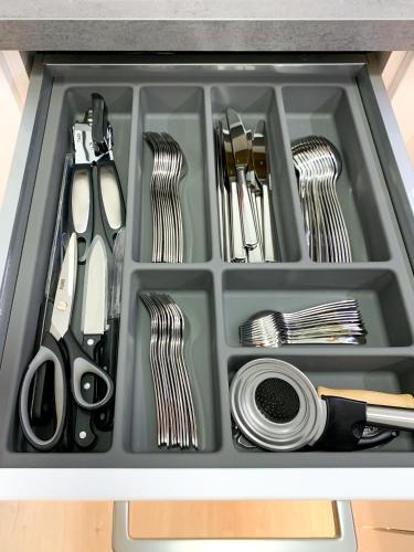a drawer filled with utensils in a sink at FeWo Längl -Alpenguck- mit Pool und Sauna im Allgäu in Scheidegg