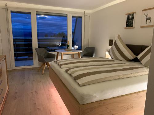 ein Schlafzimmer mit einem großen Bett und einem Balkon in der Unterkunft FeWo Längl -Alpenguck- mit Pool und Sauna im Allgäu in Scheidegg