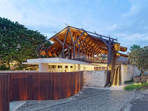 a large building with a wooden roof at The Bale Nusa Dua by LifestyleRetreats in Nusa Dua