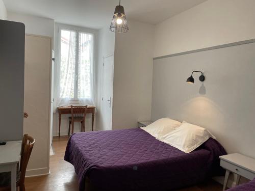 A bed or beds in a room at Hôtel du Clos Fleuri