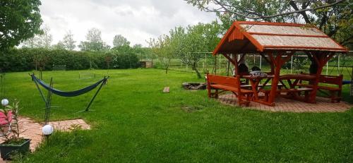 a gazebo with a hammock in a yard at Robitel Wellness Vendégház Veszprém-Gyulafirátót in Veszprém
