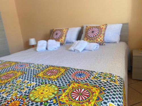 1 dormitorio con 2 camas y almohadas coloridas en Le Maioliche Gialle Sferracavallo, en Sferracavallo