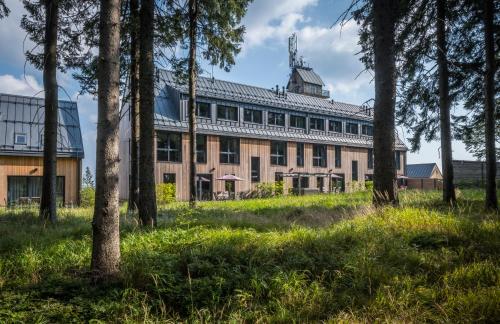 a large building with trees in the foreground at Hotel Královka in Bedřichov