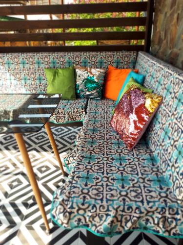 a couch with colorful pillows sitting on a floor at Guest House Barkhat in Zatoka