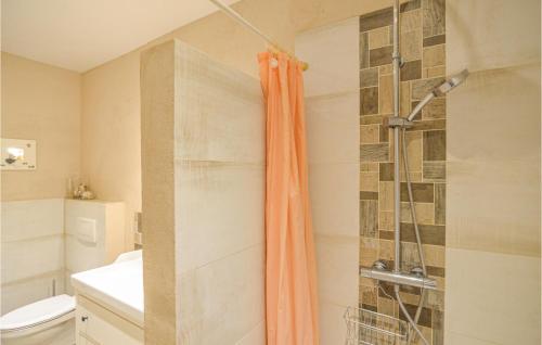 a bathroom with a shower with an orange shower curtain at 3 Bedroom Cozy Home In Thandorf in Thandorf