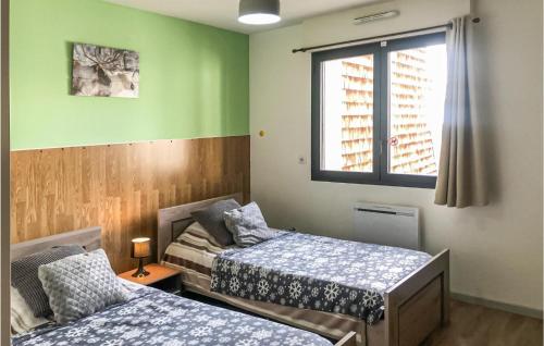 two beds in a room with green walls and a window at Rsidence Solyneou in La Mongie