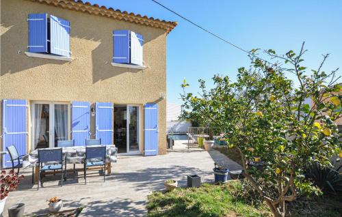 une maison avec des portes bleues, une table et des chaises dans l'établissement 2 Bedroom Stunning Home In La Farlede, à La Farlède