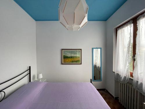 a bedroom with a bed with a purple bedspread at Villa Rosa in Giustenice