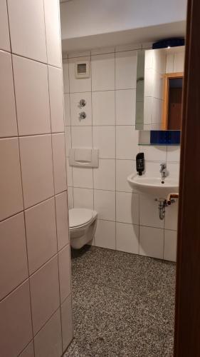 a bathroom with a toilet and a sink at Hotel Kartäuser Hof Mainz Bodenheim in Bodenheim