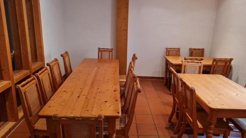 a dining room with wooden tables and chairs at Hotel Kartäuser Hof Mainz Bodenheim in Bodenheim