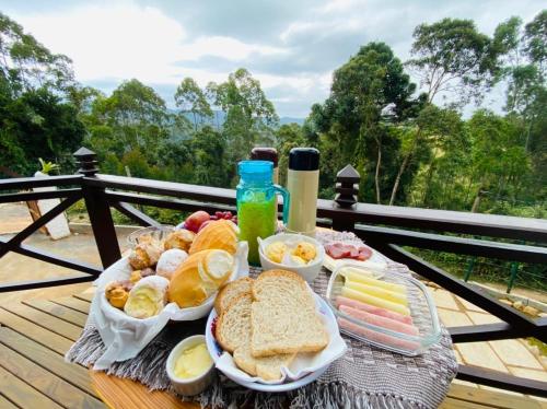 a tray of food with bread and other foods on a table at Chalés Descanso na Serra in Monte Verde
