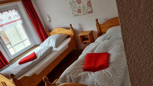 a bedroom with two beds with red pillows on them at Hotel Kartäuser Hof Mainz Bodenheim in Bodenheim