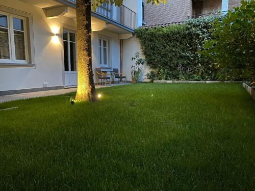 a lawn with a tree in the middle of a yard at Garden Lodge in Stresa