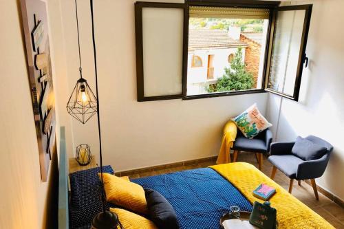 a bedroom with a bed and a window and a chair at Casa El calado in Viguera