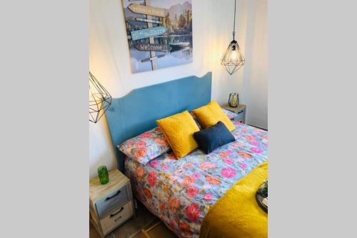 a bedroom with a bed with a blue headboard and yellow pillows at Casa El calado in Viguera