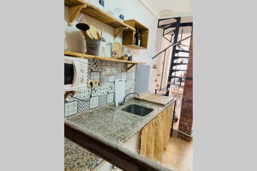 a kitchen with a sink and a microwave at Casa El calado in Viguera